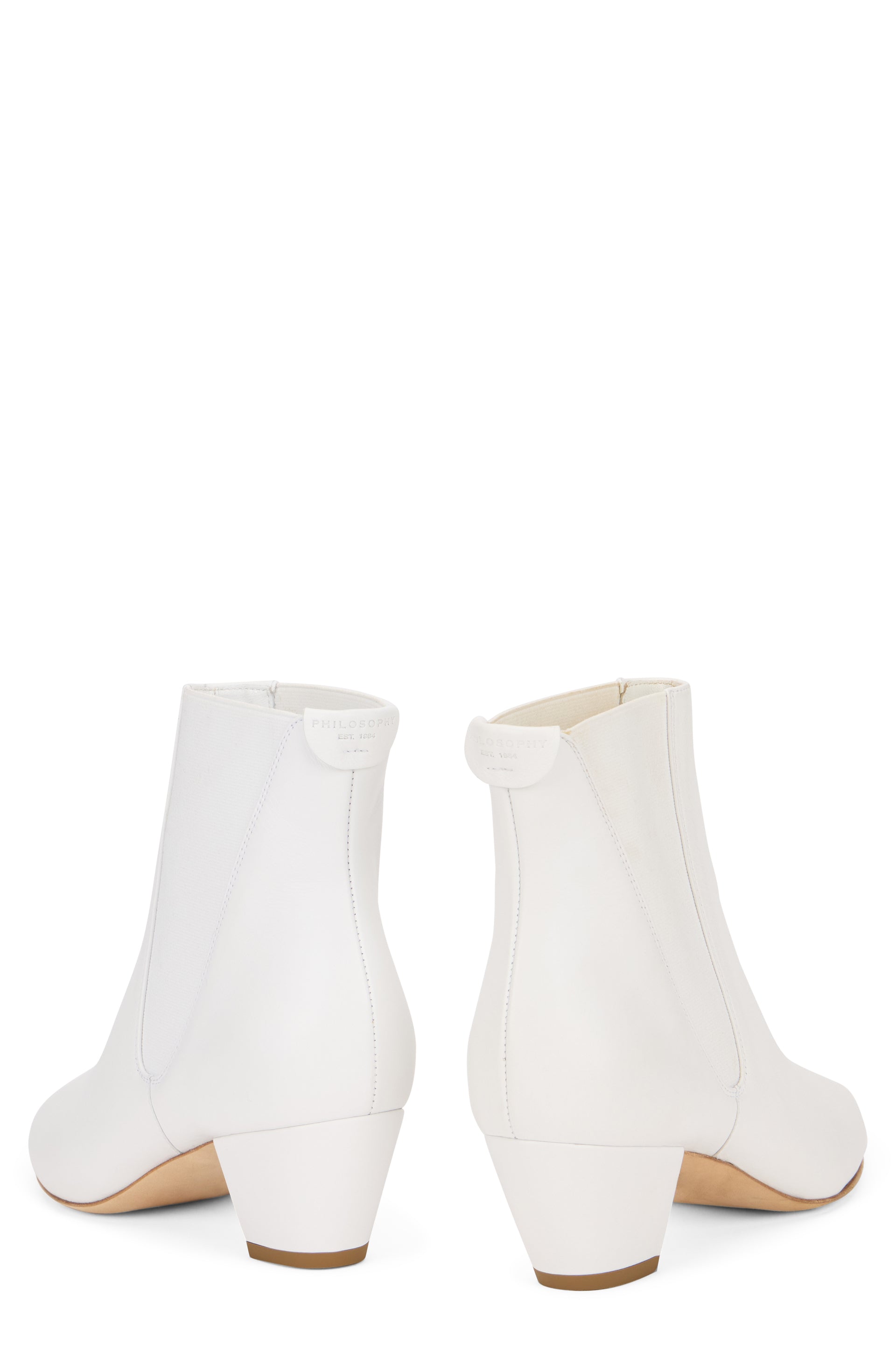 White ankle boot with elastic insert and low heel.