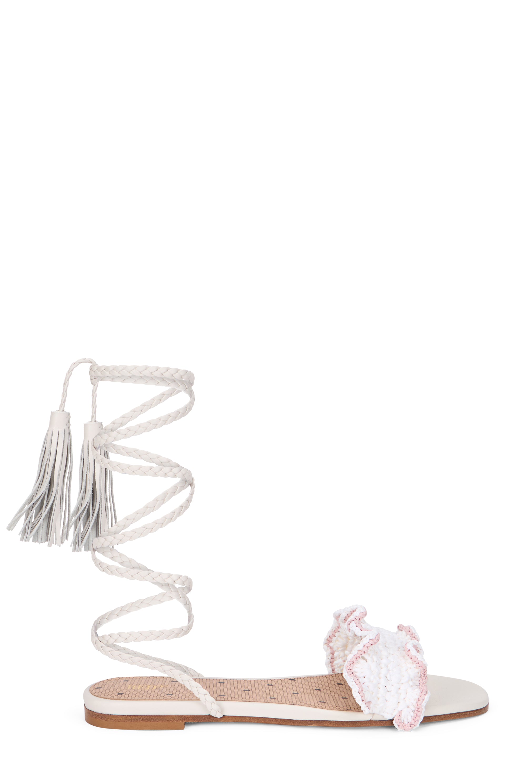 Elegant and minimalist cream-colored sandals with a long strap around the calf.