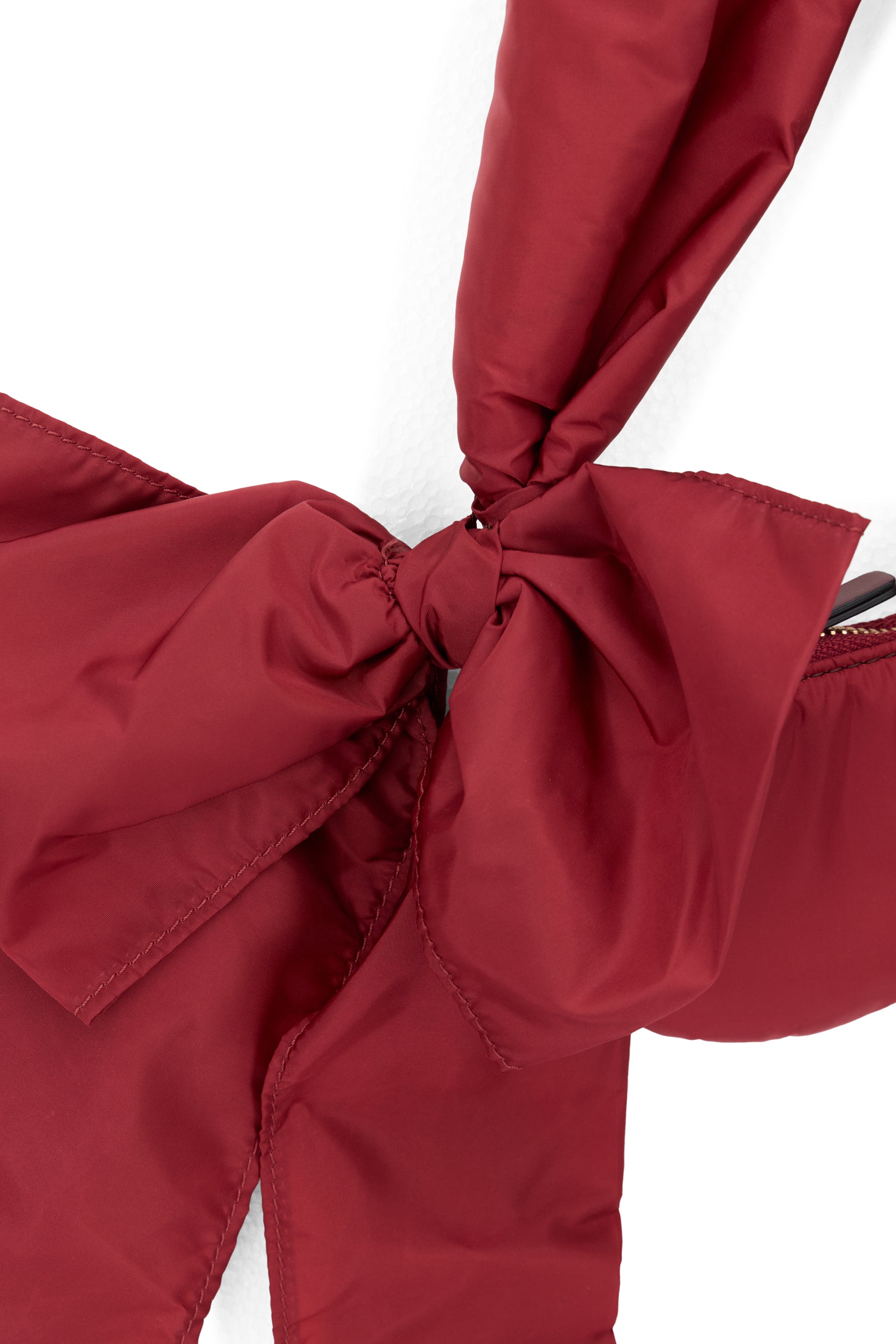 Elegant small shoulder bag in marsupial style in burgundy color.