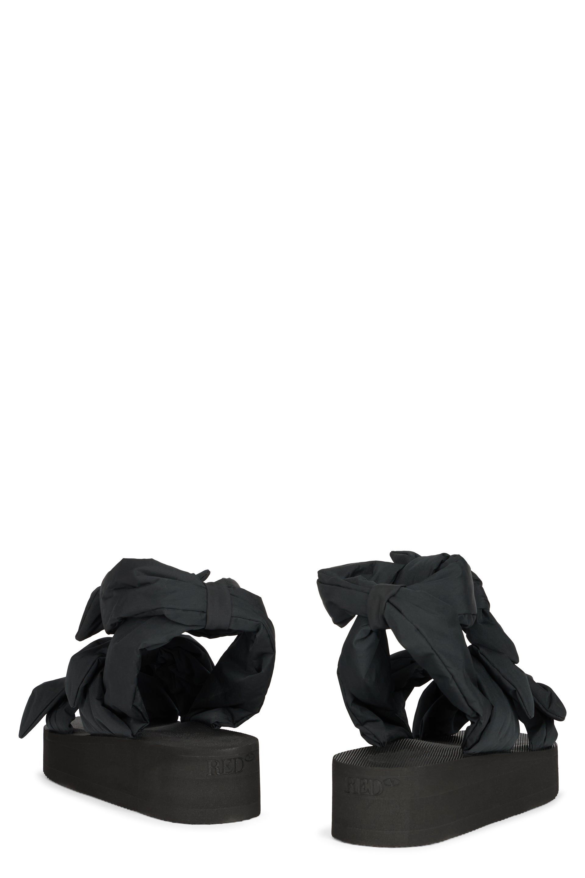 Modern black sandal with platform and wraparound strap.